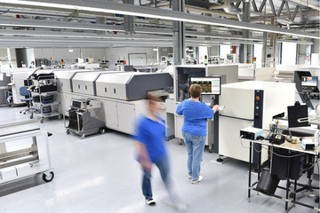 Maschinen und Arbeiter in einer Fabrik zur Montage in der Mikroelektronik - Bestückung von...