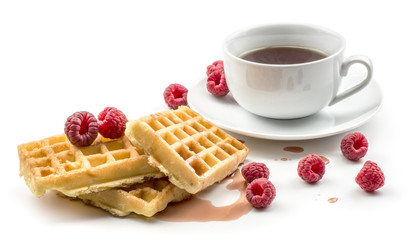 Traditional waffle (Belgian) with fresh red raspberries syrup and cup of tea isolated on white background three sweet delicate and airy delicious breakfast.