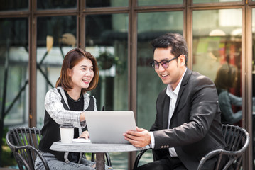 Business woman sitting at cafe outdoor and discussing with her team.