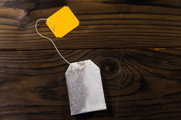 Tea bag on wooden table. Top view