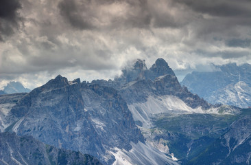 Dolomiti di Sesto ridges and rock faces with Tre Cime Drei Zinnen peaks and Val Fiscalina Fischleintal valley in low dark grey clouds in summer afternoon, Bolzano Alto Adige Sudtirol Italy Europe