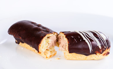 Appetizing sweet dessert. Dark glaze cupcake with cream on light background, selective focus