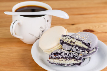 French sweet cookies marshmallows and cup of coffee on the wooden table