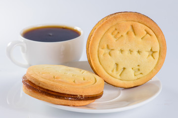 French sweet cookies and cup of coffee on light background