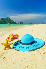 Fototapeta na wymiar Out of the office Straw hat starfish and sandals onPoda island beach white sand and turquoise sea