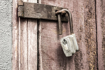 Old padlock on a background of a wooden door