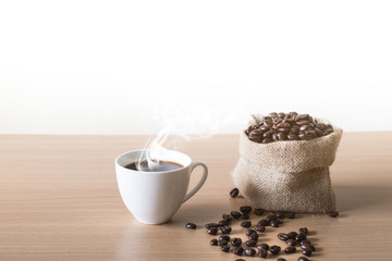 Coffee cup with coffee beans placed on a wooden table.