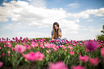 Young beauty relaxing in the tulip fields with beauty sky