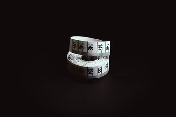 Measuring tape thread on a black background