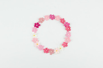Pink tone paper flowers round wreath on white background with copy space
