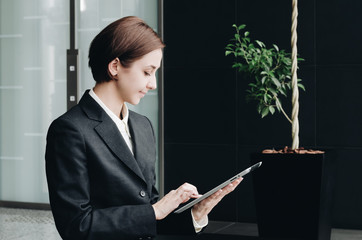 オフィスのロビーでタブレットPCを使用する女性