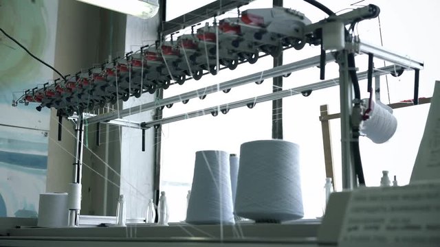 White thread spools at rewinding machines view