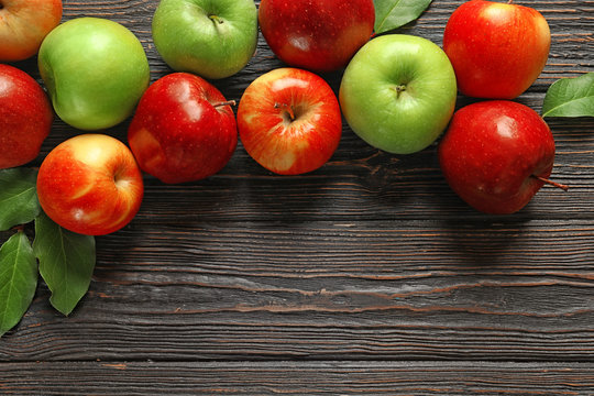 Ripe juicy apples on wooden table, top view