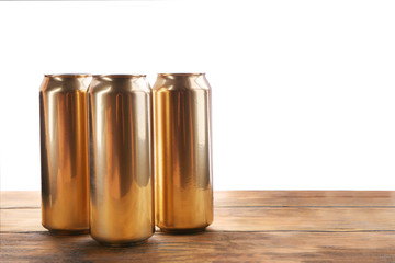 Cans of beer on wooden table against white background