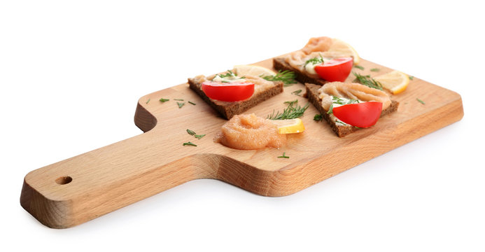 Wooden board with delicious cod caviar appetizers on white background