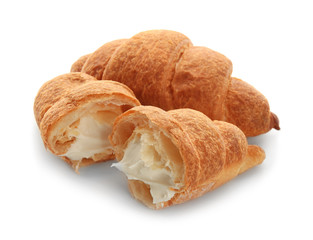 Tasty croissants with cream on white background