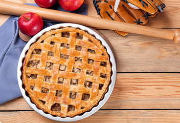 Delicious American apple pie with baseball equipment on table