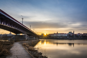 Sunset over the Royal castle and old town on the other side of  Vistula river in Warsaw, Poland