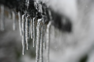 Obraz na płótnie Canvas lange Eiszapfen im kalten Winter im Hintergrund Schnee