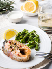 Healthy food. Baked red fish, pink salmon, salmon and green beans with a slice of lemon on a plate.