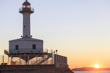 Ancient lighthouse, Far de la Banya in port of  Tarragona,Spain. - obrazy, fototapety, plakaty