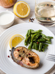 Healthy food. Baked red fish, pink salmon, salmon and green beans with a slice of lemon on a plate.