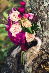 Obraz na płótnie Canvas A wedding bouquet stands near the old textured stump