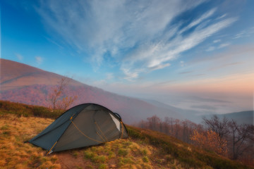 Tourist tent in camp among meadow in the mountain at sunrise.Tourist camp in a mountains. Carpathian, Ukraine, Europe. Beauty world.