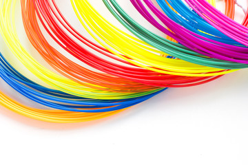 Colorful rainbow plastic filaments for 3D pen laying on white background. New toy for child.