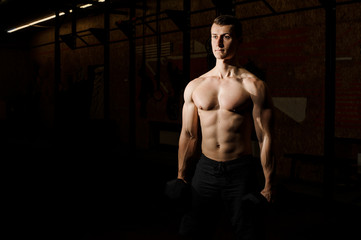 Fototapeta na wymiar Sexy shirtless man practicing crossfit in a gym