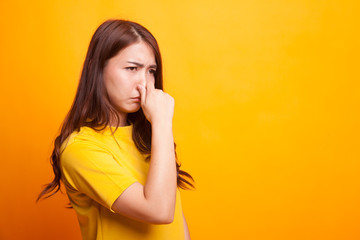 Young Asian woman  holding her nose because of a bad smell.