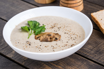 A bowl of mushroom soup cream on the table