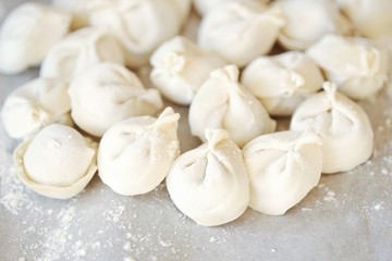 Fototapeta na wymiar Homemade dumplings and flour on the table 