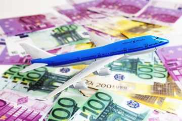 Blue white airplane on dollar and euro in cash close-up. Financial concept. tourist concept.