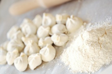Fototapeta na wymiar Homemade dumplings and flour on the table