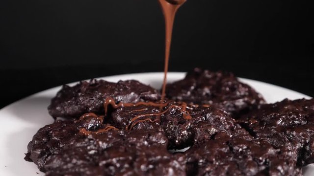 home cookies pour hot chocolate, close-up, black background, slow-motion shooting