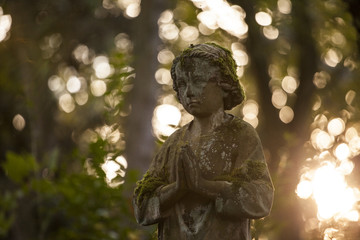 Stone statue of y young boy in golden light