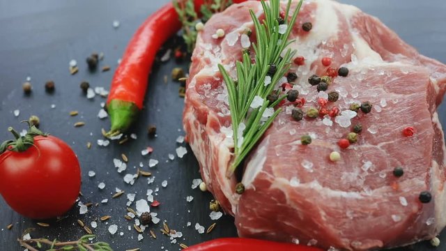 close-up view of raw beef steak and falling salt with spices. delicious dish professional cooking master restaurant food fresh vegetables meat black table red hot chilli pepper recipe ingredients