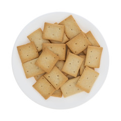 Top view of a plate filled with hard bread crackers isolated on a white background.