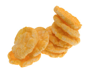 Cheddar cheese rice cakes in a messy stack isolated on a white background.
