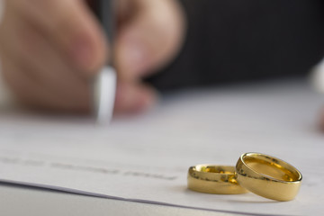 Hands of wife, husband signing decree of divorce, dissolution, canceling marriage, legal separation documents, filing divorce papers or premarital agreement prepared by lawyer. Wedding ring - 194439460