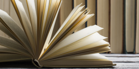 Naklejka premium Open book, hardback books on wooden table. Back to school. Copy space