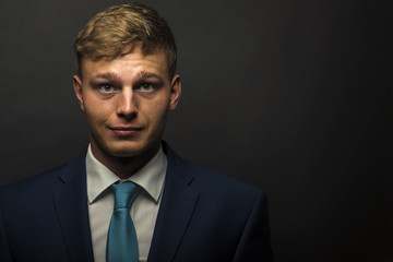 Businessman in suit over dark background portrait.