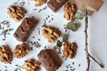 Chocolate candies, nuts and lavender on the white wooden table. Beautiful food flat lay.