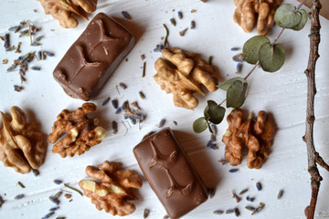 Chocolate candies, nuts and lavender on the white wooden table. Beautiful food flat lay.