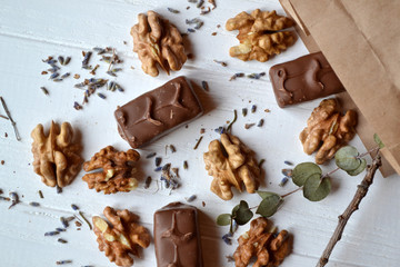 Chocolate candies, nuts and lavender on the white wooden table. Beautiful food flat lay.