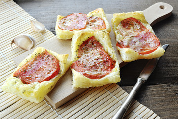 Homemade puff pastry pizzas with origan and tomatoes