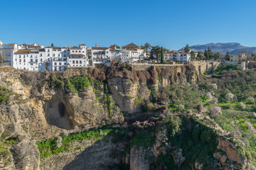 Ansicht der Stadt Ronda auf einem Berggipfel mit Wanderwegen im Vordergrund