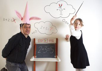 Little girl teaching mathematics to an adult dunce