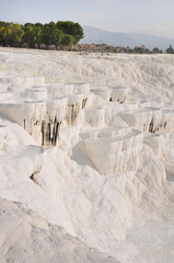 Travertines at Pamukkale in Aegean coast Turkey. Pamukkale, meaning "cotton castle" in Turkish, is a natural site in Denizli in southwestern Turkey..